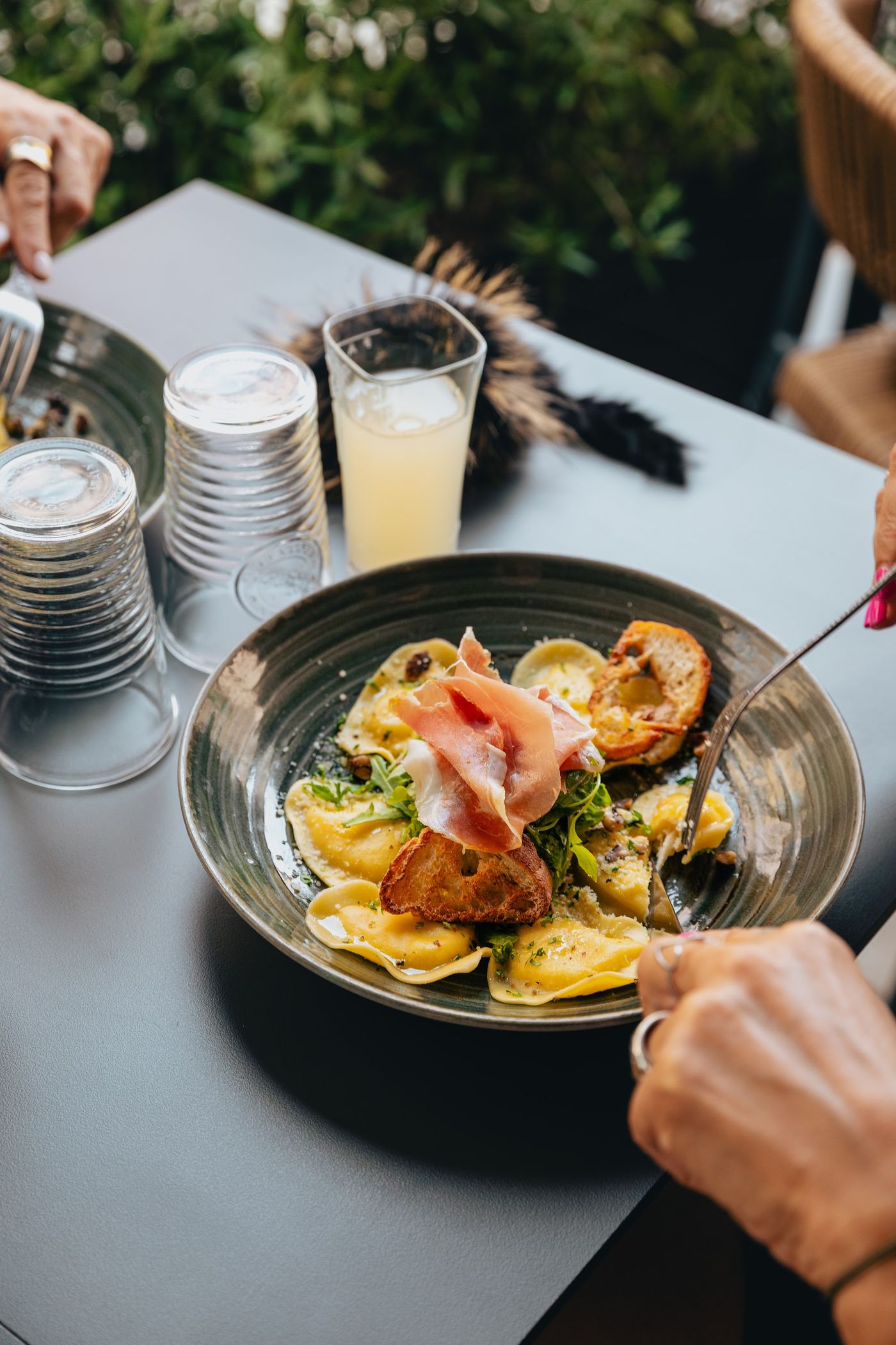 Une assiette de raviolis, servie en terrasse.